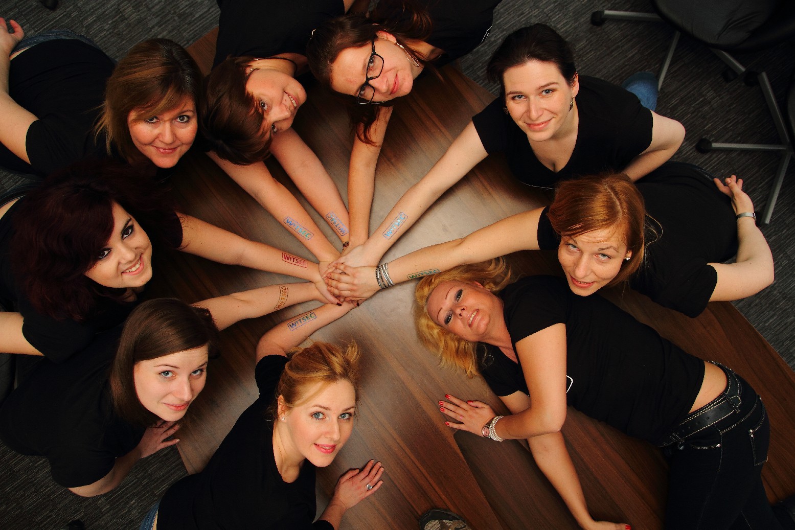 WITSEC alapítótagok egy asztal körül felfelé néznek